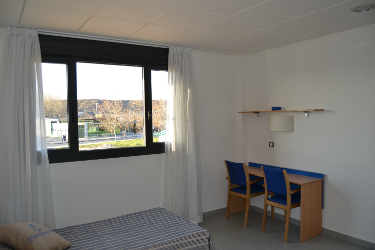 cama y escritorio con vistas a la calle de Campolar Bierzo